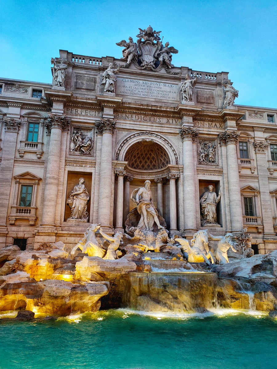 People Sitting on Rock Statue in Front of Building